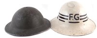 Lot 226 - Two helmets, one a Brodie helmet in green the other a Zuckerman  fire leaders helmet.