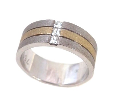 Lot 126 - A diamond three stone set 18ct white and yellow gold three section band ring.