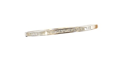 Lot 64 - An 18ct gold diamond hinged bangle