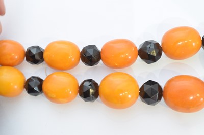 Lot 184 - A butterscotch amber and jet necklace.
