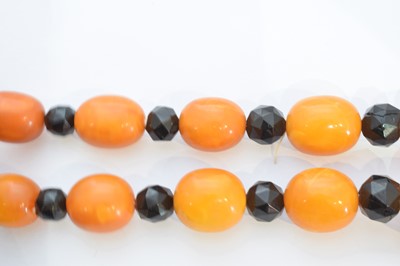 Lot 184 - A butterscotch amber and jet necklace.