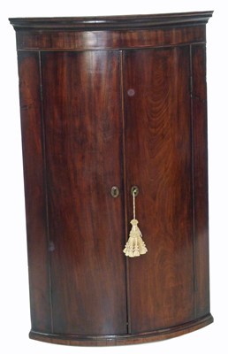 Lot 385 - George III mahogany bow-front corner cupboard