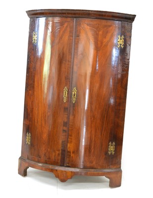 Lot 320 - George III mahogany two-door bow front hanging corner cabinet