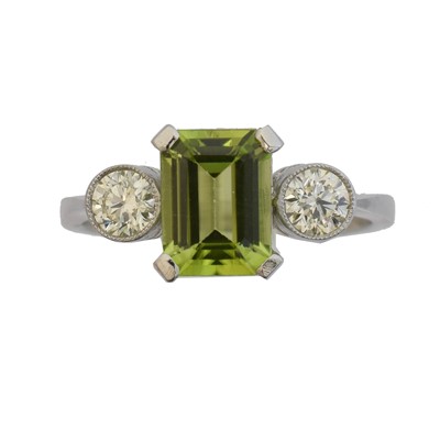 Lot 126 - A peridot and diamond three stone ring.