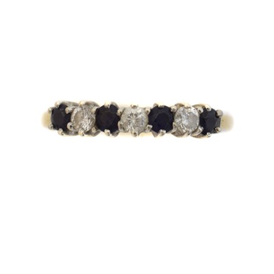 Lot 74 - A diamond and sapphire band ring.