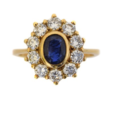 Lot 166 - A sapphire and diamond cluster ring.