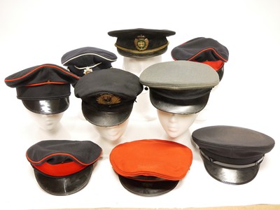 Lot 174 - Twenty one peaked caps, six with badges, the...