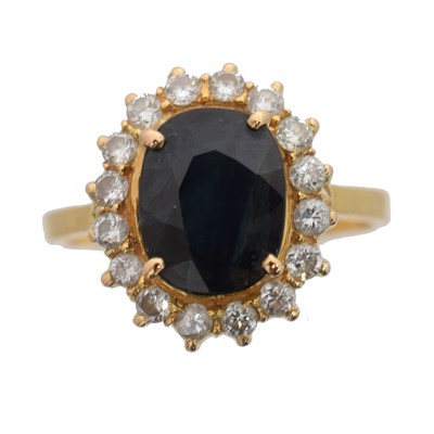 Lot 129 - A sapphire and diamond cluster ring.
