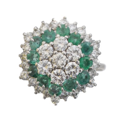 Lot 100 - An emerald and diamond cluster ring.