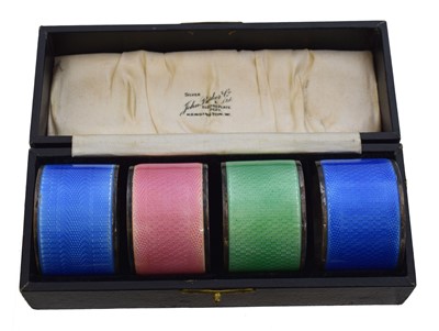 Lot 89 - A cased set of George V silver enamel napkin rings.