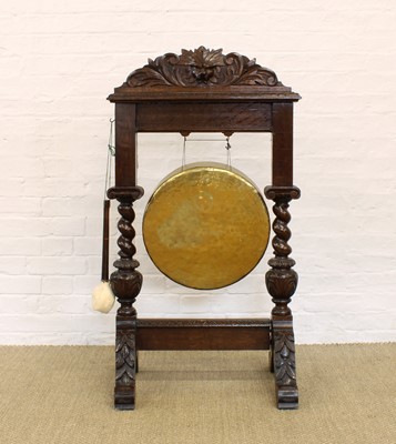 Lot 194 - A Brass Dinner Gong on Early 20th Century Carved Oak Stand