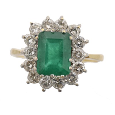 Lot 65 - An 18ct gold emerald and diamond cluster ring.