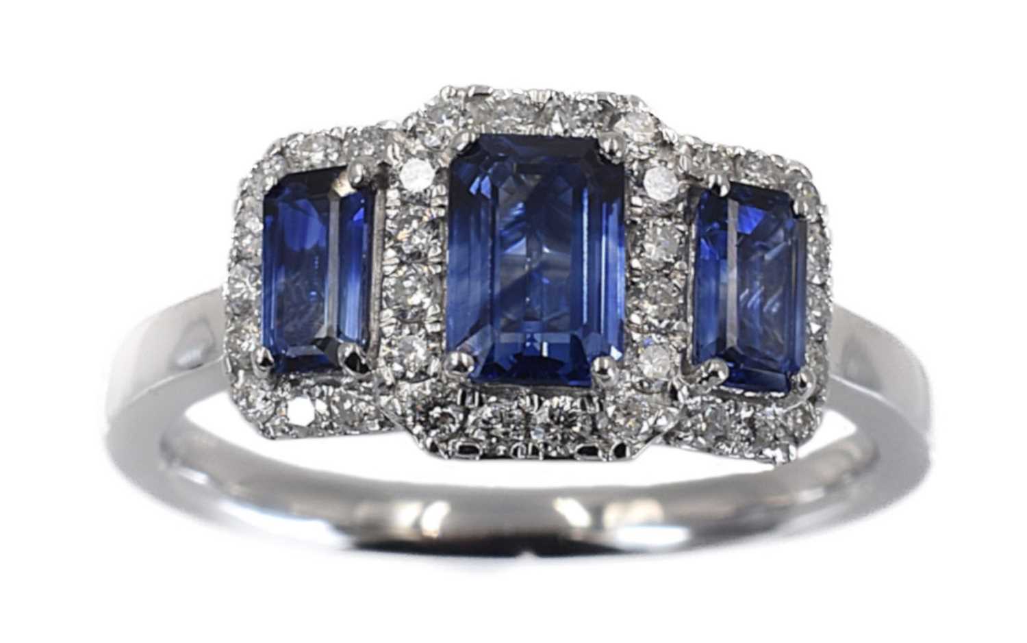 Lot 55 - A platinum sapphire and diamond cluster trilogy ring