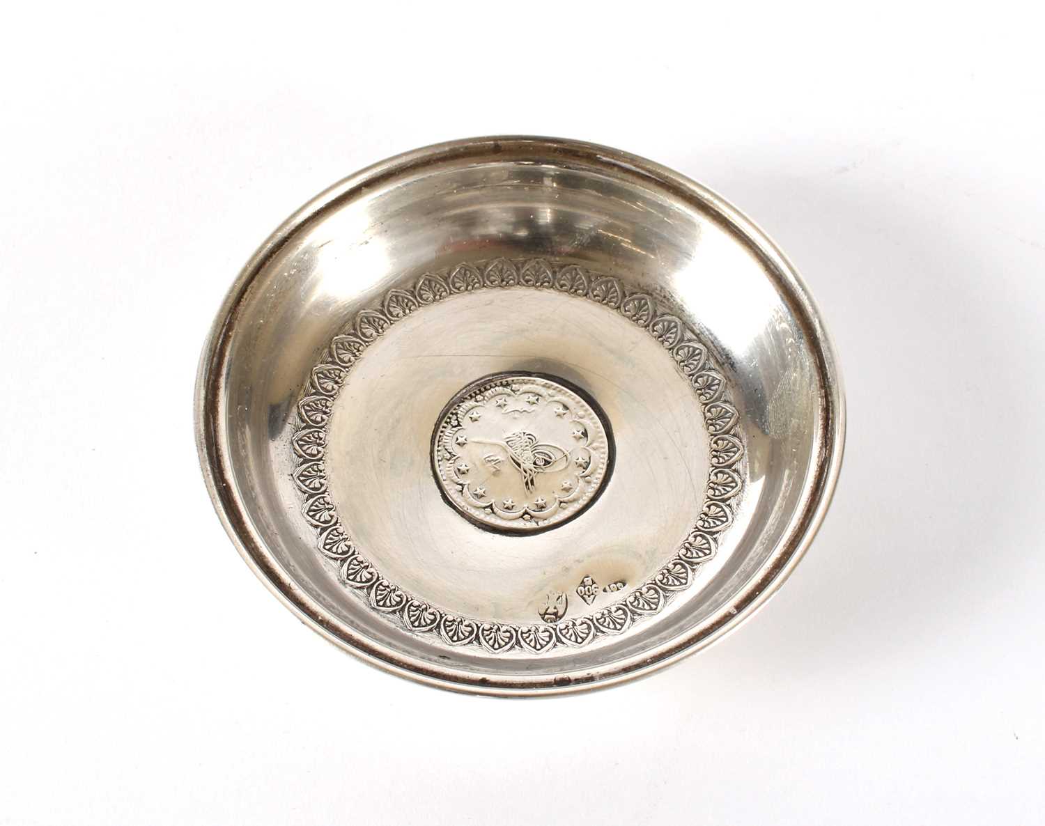 Lot 20 - An Eastern White Metal Coin Set Trinket Dish
