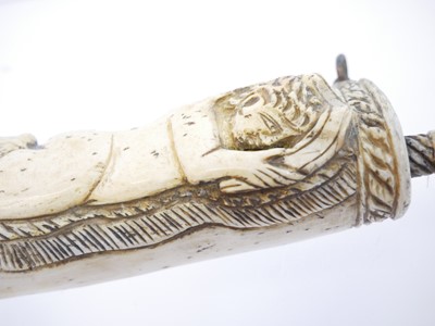 Lot 690 - Bone powder flask carved with a cherub holding...