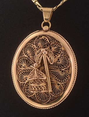 Lot 255 - A rose-tone filigree pendant on a yellow gold chain