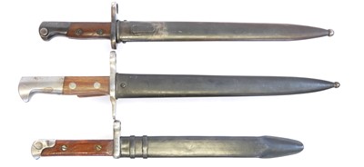 Lot Three bayonets and scabbards, including a...