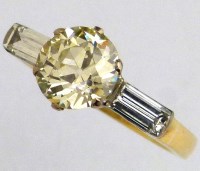 Lot 327 - Single stone diamond ring on baguette shoulders.