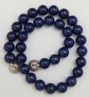 Lot 428 - Lapis lazuli bead necklace with a silver covered