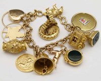 Lot 393 - Gold charm bracelet, charms and a gilt fob.