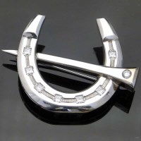 Lot 341 - White gold and diamond horse shoe brooch.