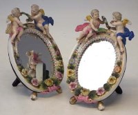 Lot 268 - Pair of cherub mounted porcelain mirrors.