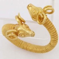 Lot 554 - Middle Eastern gold rams heads sprung bangle