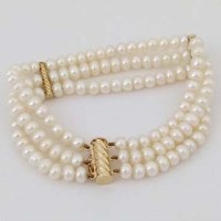 Lot 556 - Fresh water pearl three-strand bracelet on 9ct gold mount.