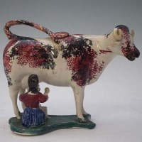 Lot 141 - Staffordshire cow creamer.