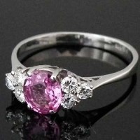 Lot 288 - Oval pink sapphire, 1.39ct, flanked by six