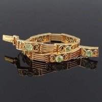 Lot 295 - 15ct gold and peridot bracelet, circa 1930, the