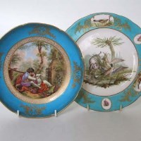 Lot 575 - Two Sevres dishes one painted with a couple reading within a garden scene, the other with a dog suprising a mallard and duck