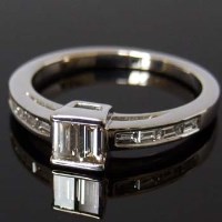 Lot 283 - Emerald-cut diamond ring, the central square