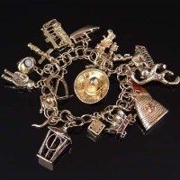Lot 305 - 10k gold charm bracelet, 68.4g