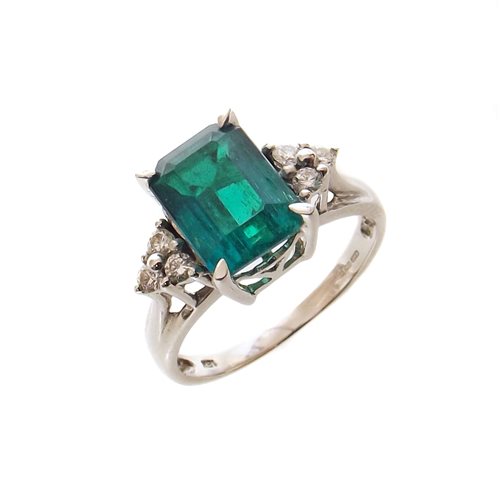 Lot 60 - Emerald single stone 18ct white gold ring with diamond set shoulders