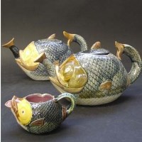 Lot 587 - Two Majolica teapots and a cream jug