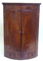 Lot 724 - George III mahogany bow front corner cupboard.