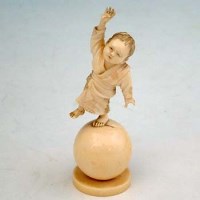 Lot 675 - Ivory figure of a boy on a ball.
