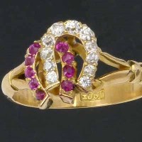 Lot 320 - Ruby and diamond horseshoe ring