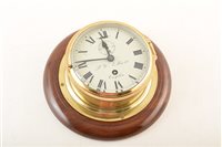 Lot 362 - A mid 20th century brass bulkhead ships clock on mahogany backboard by F. W Elliott, Croydon