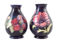 Lot 205 - Two Moorcroft vases decorated with Clematis and Anemone pattern on a blue ground, impressed marks to base, the Anemone vase has a silver line, 13.5cm high