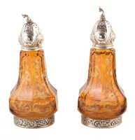 Lot 364 - Two German amber glass and silver pepperettes
